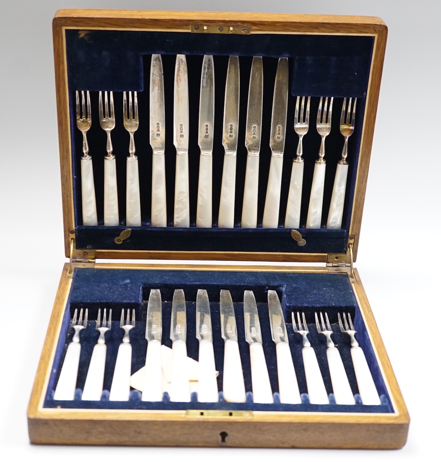 A cased set of twelve pairs of George V mother of pearl handled silver dessert eaters, Isaac Ellis & Sons, Sheffield, 1924.